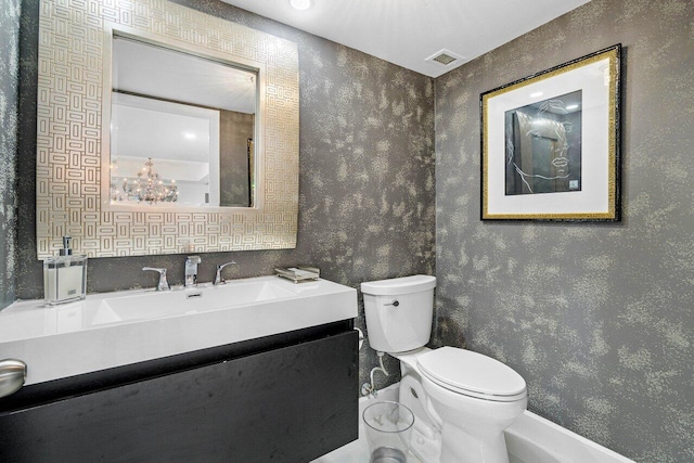 600 S Ocean Blvd Unit 1207, Boca Raton, FL 33432 - bathroom with wallpapered walls, toilet, and vanity