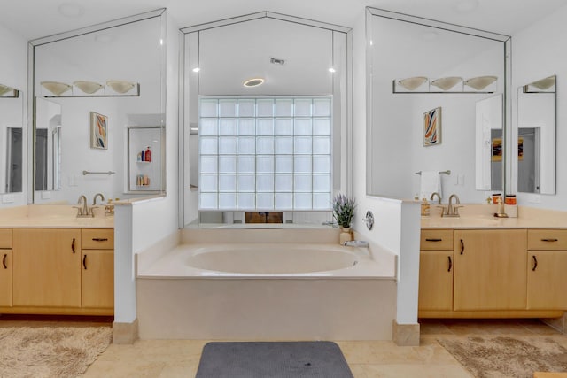 bathroom featuring vanity, tile patterned floors, and a washtub