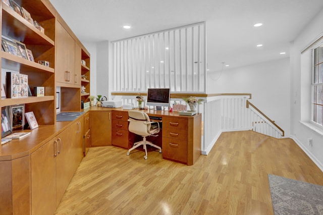 office featuring built in desk and light hardwood / wood-style floors