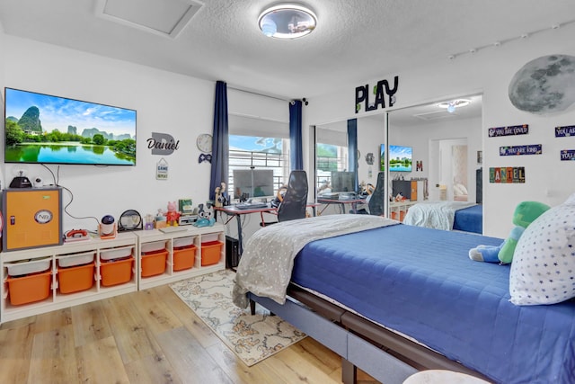 bedroom featuring hardwood / wood-style flooring and a textured ceiling