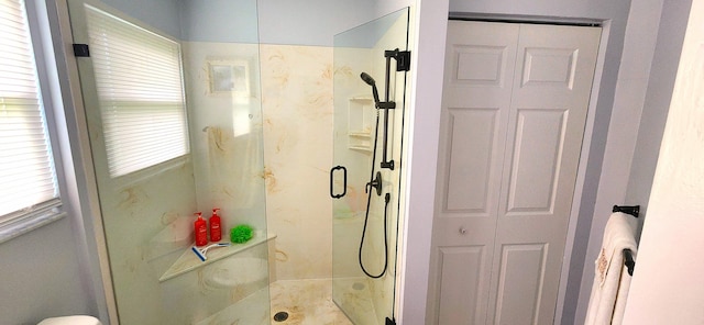 bathroom with a shower with door and a wealth of natural light