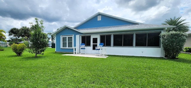 back of property featuring a lawn, a patio, and a sunroom