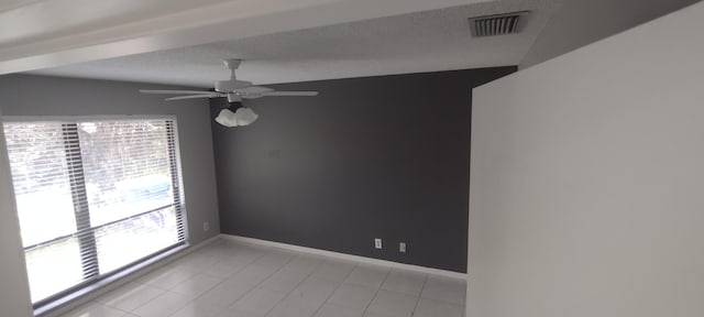 spare room featuring a textured ceiling, ceiling fan, vaulted ceiling, and light tile patterned flooring