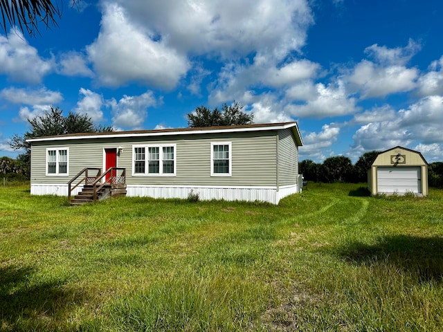 manufactured / mobile home with an outdoor structure, a garage, and a front lawn