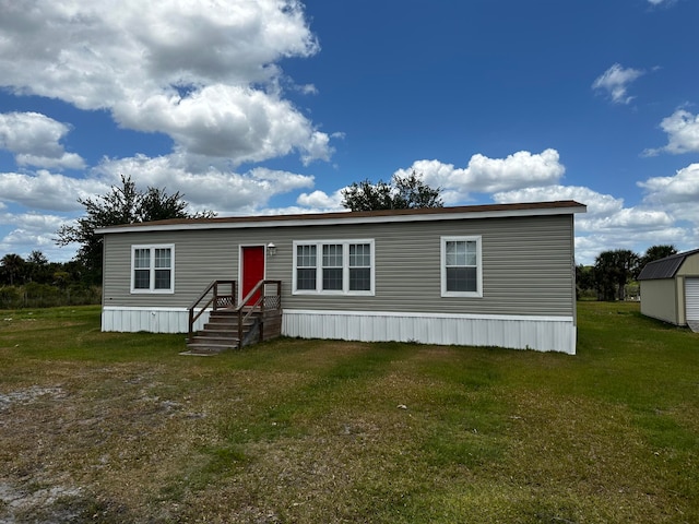 manufactured / mobile home with a storage shed and a front lawn