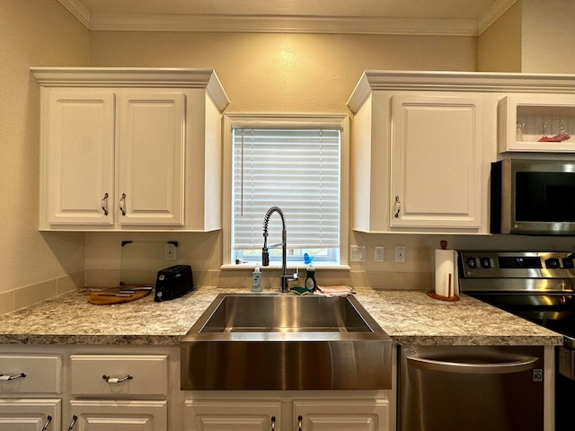 kitchen featuring ornamental molding, stainless steel appliances, white cabinetry, and sink