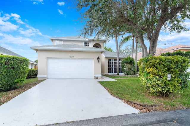 traditional home with a front yard, a garage, driveway, and stucco siding