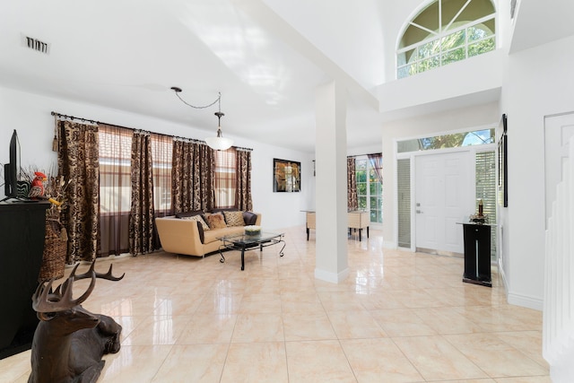 foyer with visible vents, baseboards, and a towering ceiling