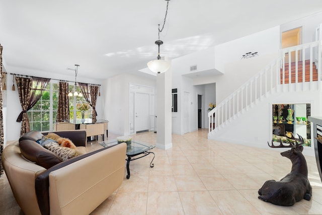 living room with visible vents, baseboards, stairs, light tile patterned floors, and an inviting chandelier