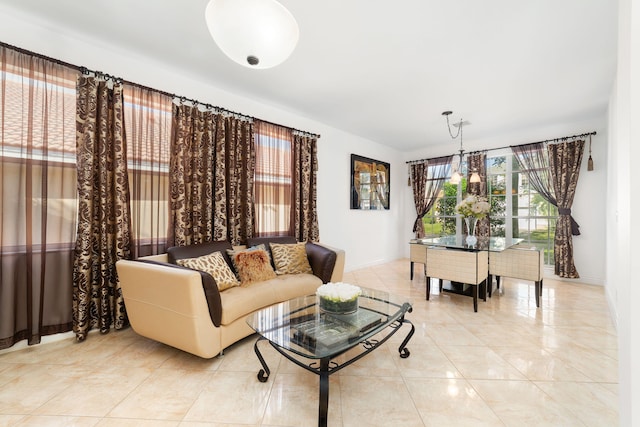 living area featuring an inviting chandelier and baseboards