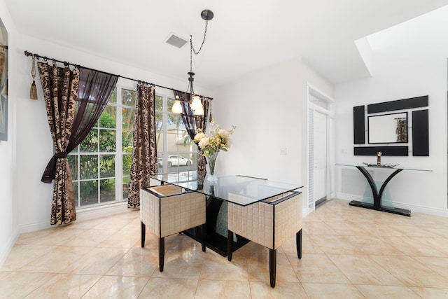 dining room with light tile patterned floors, a healthy amount of sunlight, visible vents, and baseboards