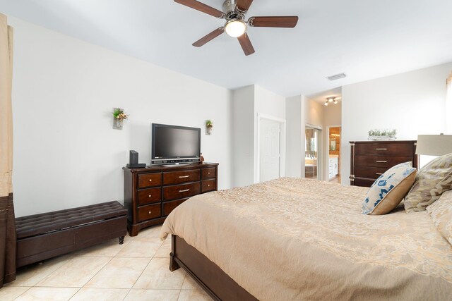 bedroom featuring light tile patterned floors, a ceiling fan, visible vents, and connected bathroom