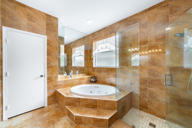 bathroom featuring tile walls, a tub with jets, and a shower stall