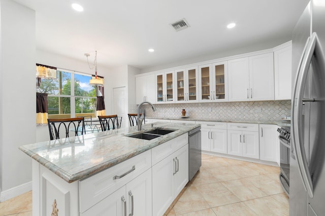 kitchen featuring visible vents, backsplash, appliances with stainless steel finishes, white cabinets, and a sink