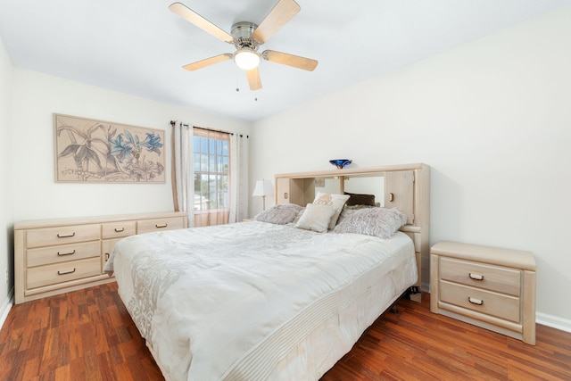 bedroom featuring baseboards, dark wood finished floors, and a ceiling fan