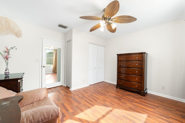 sitting room with visible vents, baseboards, wood finished floors, and a ceiling fan