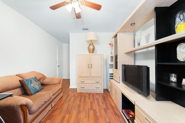 living room featuring ceiling fan, visible vents, and wood finished floors