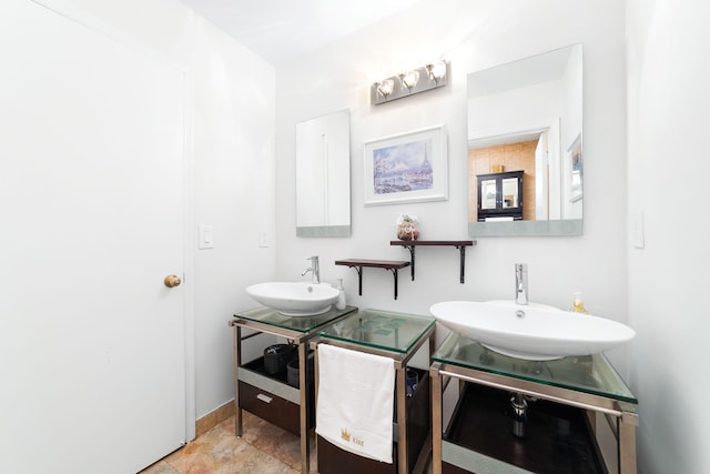 bathroom featuring baseboards and a sink