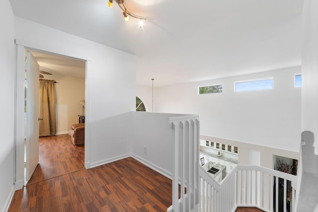 hallway featuring an upstairs landing, wood finished floors, and baseboards