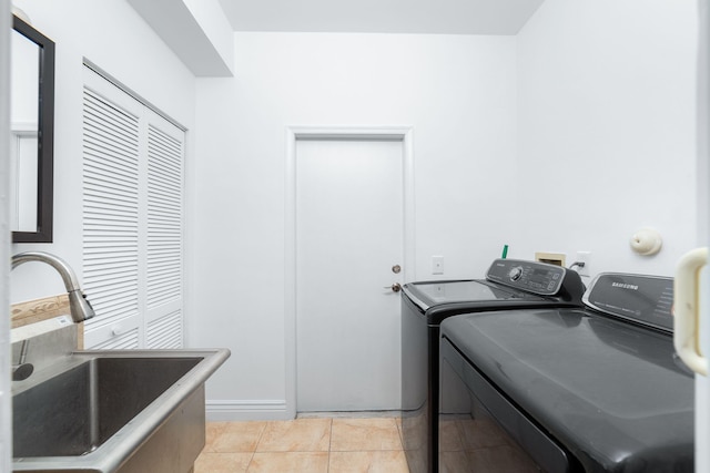 laundry room featuring a sink, independent washer and dryer, light tile patterned flooring, and laundry area