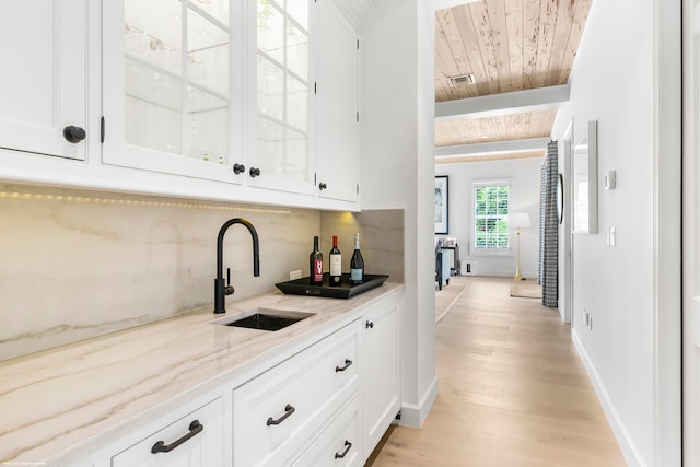 kitchen featuring white cabinetry, light hardwood / wood-style floors, sink, and wood ceiling