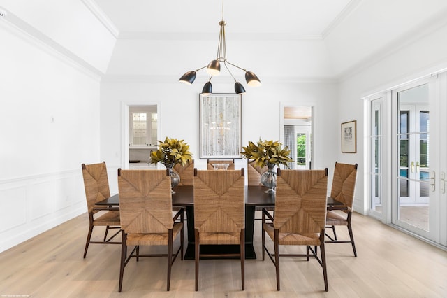 dining area with crown molding, french doors, a chandelier, and light wood-type flooring