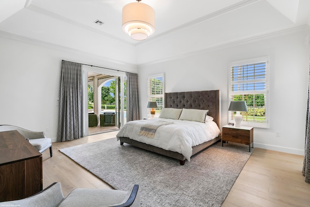 bedroom with access to exterior, light hardwood / wood-style flooring, and multiple windows