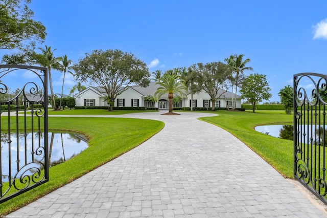 view of home's community featuring a water view and a lawn