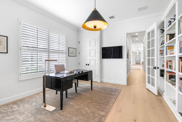 home office with ornamental molding, french doors, and light hardwood / wood-style floors