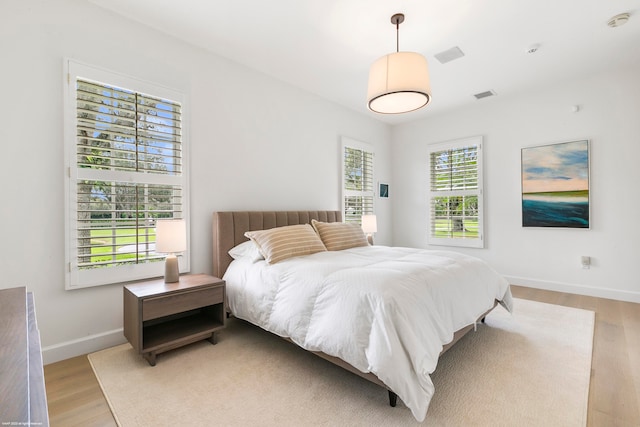 bedroom featuring light hardwood / wood-style flooring and multiple windows