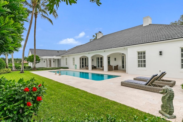 back of property featuring a patio and a lawn