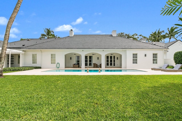 rear view of house featuring a patio area and a lawn