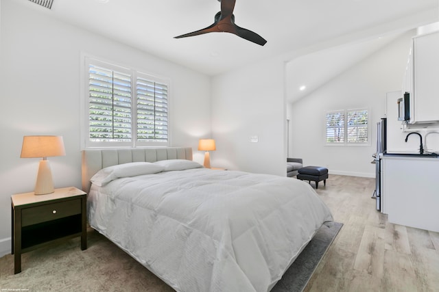 bedroom with light hardwood / wood-style flooring, ceiling fan, vaulted ceiling, and multiple windows