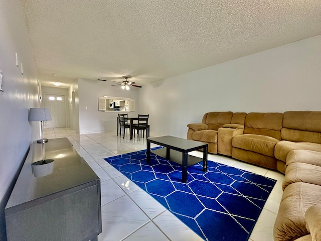 living room featuring tile patterned flooring, a textured ceiling, and ceiling fan