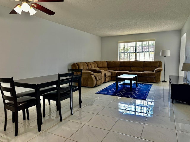 tiled living room with ceiling fan and a textured ceiling