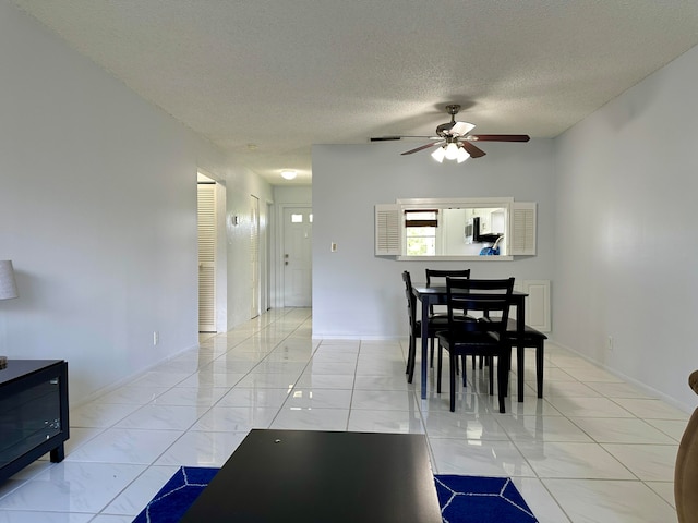 dining room featuring ceiling fan and a textured ceiling