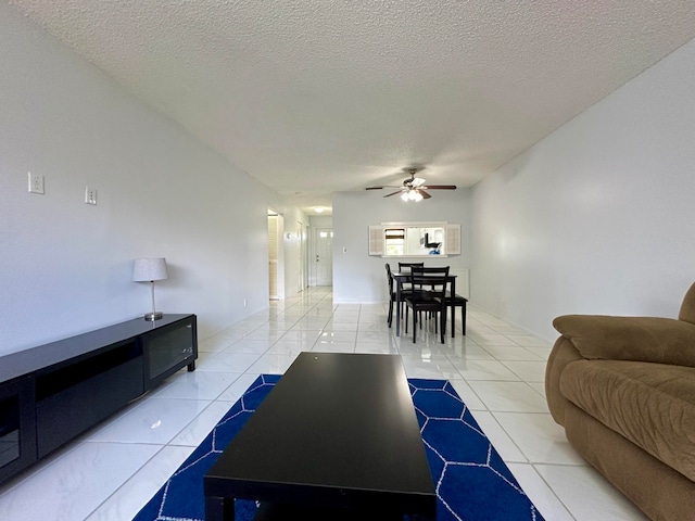 living room featuring a textured ceiling, ceiling fan, and light tile patterned floors