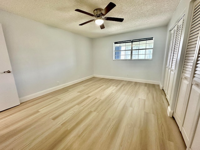 unfurnished bedroom featuring light wood-type flooring, a textured ceiling, ceiling fan, and a closet