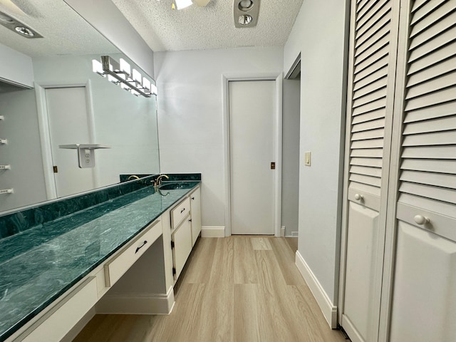 bathroom featuring a textured ceiling, hardwood / wood-style flooring, and vanity