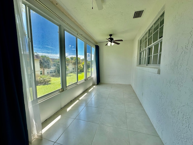 unfurnished sunroom featuring ceiling fan