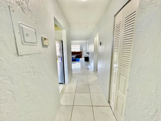 hall featuring a textured ceiling