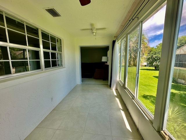 unfurnished sunroom with ceiling fan and a wealth of natural light