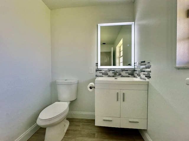 bathroom with decorative backsplash, vanity, and toilet