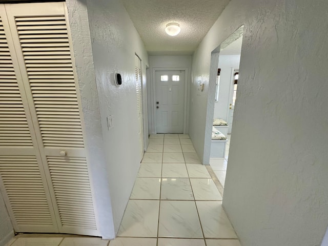 hallway with a textured ceiling