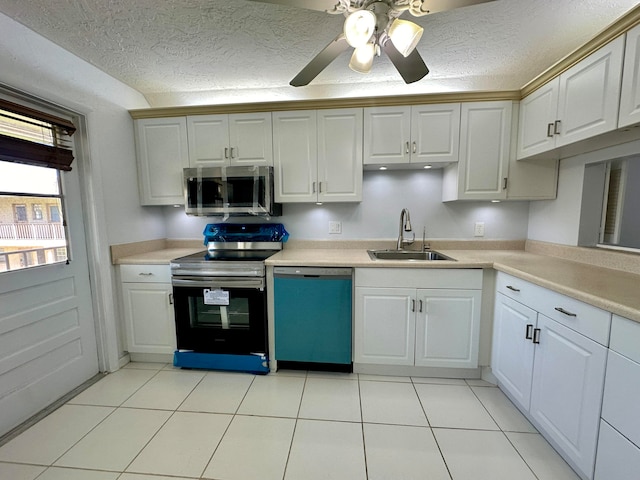 kitchen with light tile patterned floors, white cabinets, stainless steel appliances, and sink