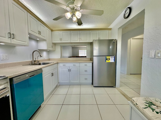 kitchen with a textured ceiling, appliances with stainless steel finishes, sink, and white cabinetry