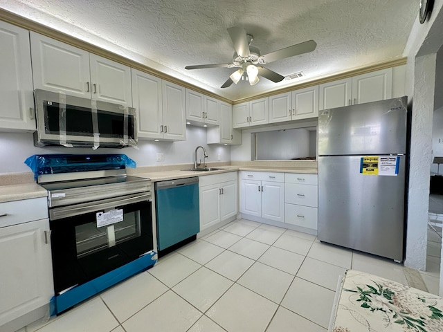 kitchen with a textured ceiling, white cabinetry, sink, and stainless steel appliances