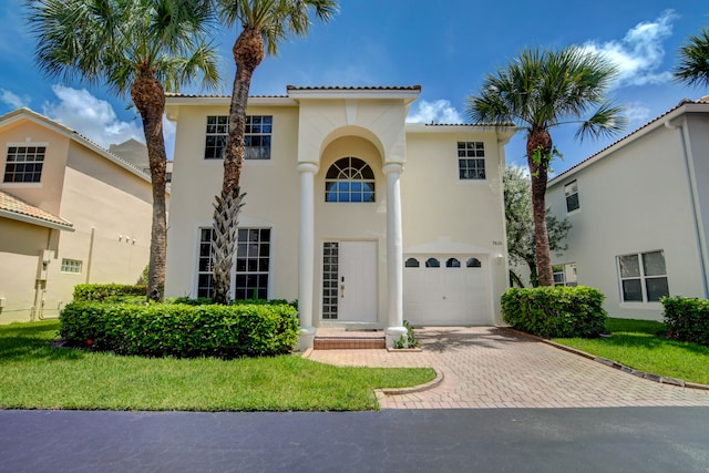 mediterranean / spanish-style house featuring a front yard and a garage