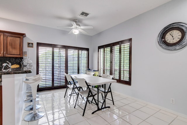 dining area featuring light tile patterned flooring, sink, plenty of natural light, and ceiling fan