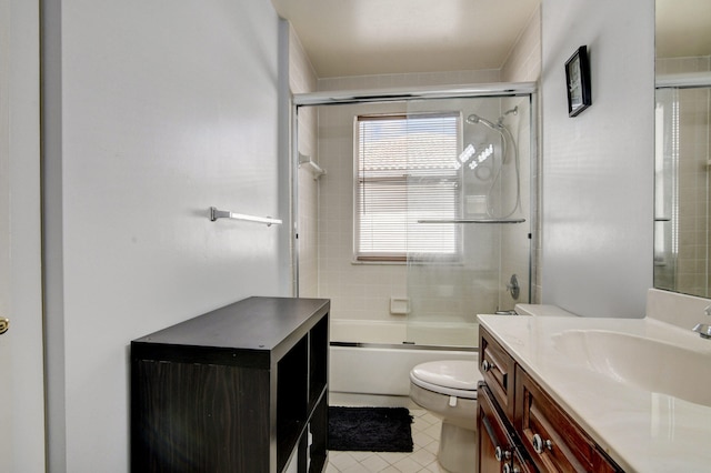 full bathroom featuring vanity, shower / bath combination with glass door, toilet, and tile patterned flooring